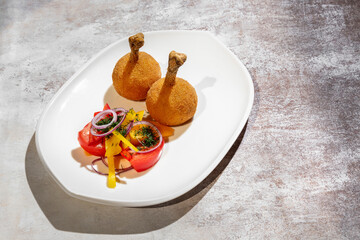 Chicken legs in batter with tomatoes