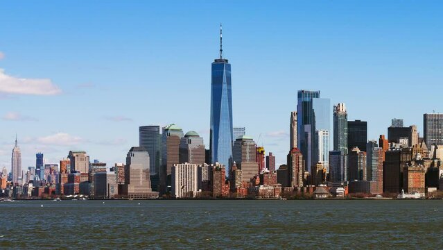 Skyscraper tower buildings in financial business district, cityscape time lapse of boat transportation on Hudson river, Manhattan New York City, USA. American city life, United States downtown concept