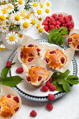 muffins with raspberries on a light table decorated in a summer style. concept home baking, summer baking, holiday, summer tea party, dessert, summer desserts, romantic evening, valentine's day