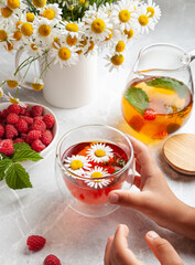 the child holds in his hands a cup of tea with herbs and berries the concept of healthy eating, tea drinking, herbal tea