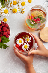 the child holds in his hands a cup of tea with herbs and berries the concept of healthy eating, tea drinking, herbal tea