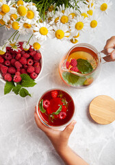 the child holds in his hands a cup of tea with herbs and berries the concept of healthy eating, tea drinking, herbal tea