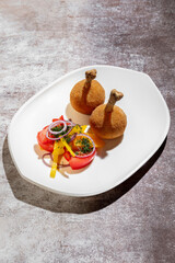 Chicken legs in batter with tomatoes