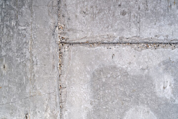 View of the concrete wall inside the room, unfinished apartment. Imperfections on the wall - cracks, sagging, dirt, crumb. Preparation for renovation and finishing work.