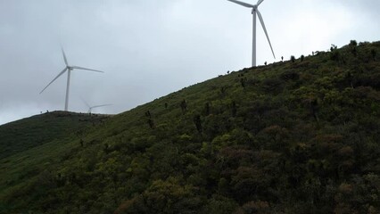 Aerial footage of windmills or aerogenerators working in the windy mountains of Mexico