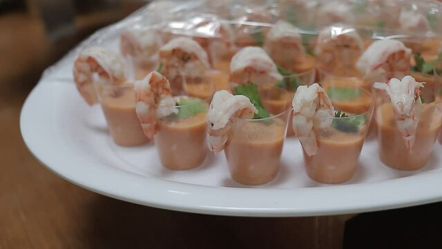 Top shot of plate with small lobsters in glasses with their sauce, detail shot.
