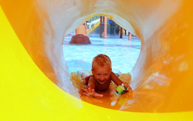 A boy is cheerful playing in the pool at the water park in the summer on a sunny day selective...