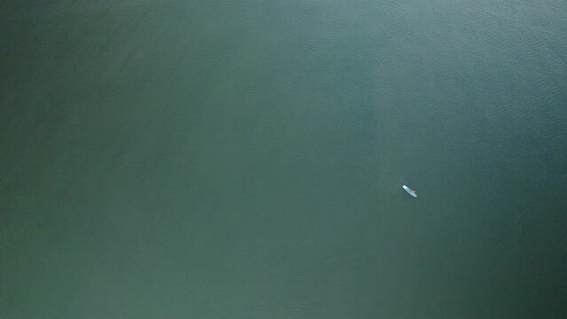 One person practicing Stand Up Paddle Boarding SUP in Baltic sea - Top-down aerial view 