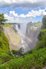 The iconic Victoria Falls, aka Mosi-Oa-Tunya waterfall, view from the Zimbabwe side with a rainbow.