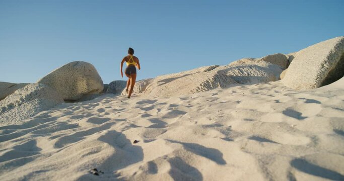 Active, fit and sporty athlete running, jogging and sprinting on sand, shore and coast at the beach. Motivated, dedicated and fast woman with stamina doing workout, exercise and training by the ocean