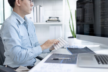 Professional development programmers are sit on a desk with work equipment such as: computer-laptop-tablet. for working in programming or writing code on  website,  HTML, javascript, Software.