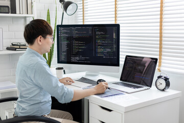 Professional development programmers are laying out a structure or draft on paper in preparation for coding on a computer, Write information or code for the website,  HTML, javascript, Software.