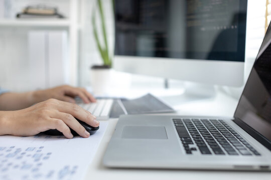 Professional development programmers are sit on a desk with work equipment such as: computer-laptop-tablet. for working in programming or writing code on  website,  HTML, javascript, Software.