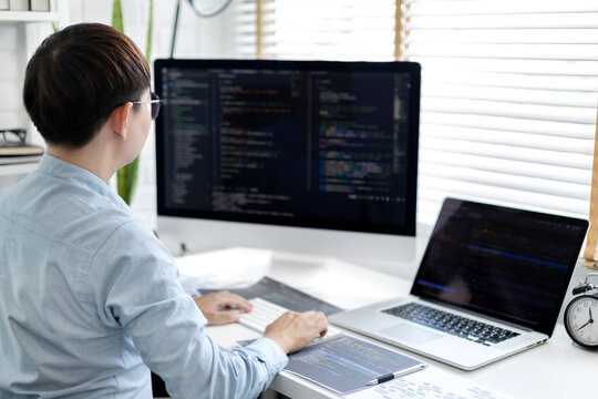 Professional development programmers are sit on a desk with work equipment such as: computer-laptop-tablet. for working in programming or writing code on  website,  HTML, javascript, Software.