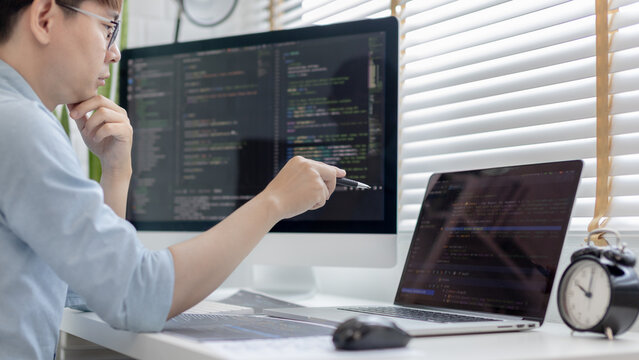Professional development programmers are laying out a structure or draft on paper in preparation for coding on a computer, Write information or code for the website,  HTML, javascript, Software.