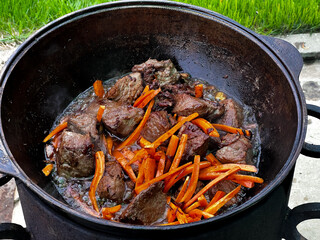 Cooking pilaf on a fire in a cauldron.