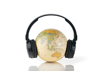 Black wireless  headphones on globe isolated on white background. Travel concept with music.