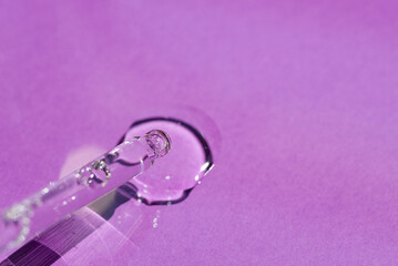 Pipette close-up on a purple background in soft focus. Beautiful shadow in the sunlight. Skincare products , natural cosmetic. Beauty concept for face and body care