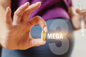 pregnant woman drinks OMEGA 3 pills. Pregnant woman holding a glass of water and vitamins for...