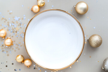 empty festive holiday dish on beige background with christmas balls and confetti, top view