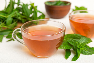 Cup of mint tea on table background. Green tea with fresh mint top view with copy space