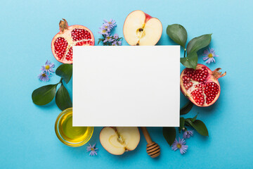 Flat lay composition with Blank flyer poster and symbols jewish Rosh Hashanah holiday attributes on colored background, New Year holiday Traditional. Top view with copy space mock up