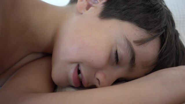 Fethiye, Turkey - 7th of July 2022: 4K Funny boy splutters when making believe as if sleeping and snoring
