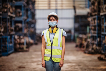 confident pose of the engineer  women wear  mask while standing in factory