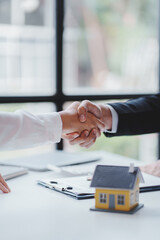 Handshake real estate agents deliver sample homes to customers. mortgage loan agreement Make a contract for hire purchase and sale of a house. and home insurance contracts home mortgage loan concept