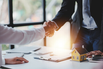 Handshake real estate agents deliver sample homes to customers. mortgage loan agreement Make a contract for hire purchase and sale of a house. and home insurance contracts home mortgage loan concept