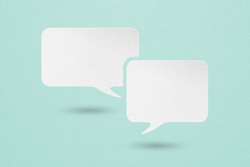 two blank white speech bubble paper cut ,  on grunge blue paper background,  Conceptual image about communication and social media