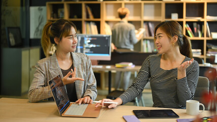 Two young software developers are brainstorming for new web site project together