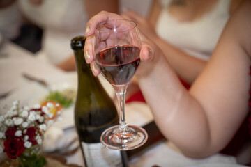femme tenant un verre de vin rouge à la main