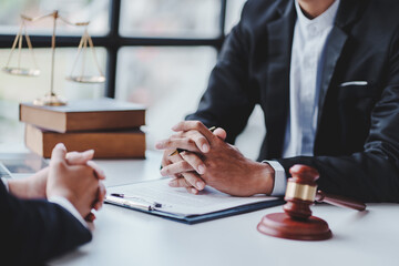 concept of justice and law A male judge in the courtroom on a wooden table and a male counselor or lawyer working in the office. Law, advice and justice concepts.