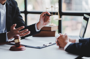 concept of justice and law A male judge in the courtroom on a wooden table and a male counselor or lawyer working in the office. Law, advice and justice concepts.