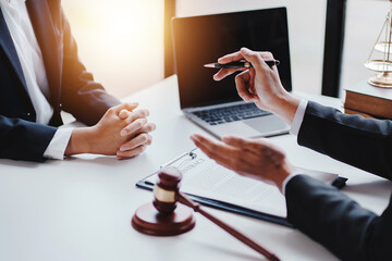 concept of justice and law A male judge in the courtroom on a wooden table and a male counselor or lawyer working in the office. Law, advice and justice concepts.