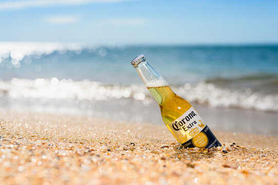 Anapa - Russia, July 2022: A bottle of cold beer Corona Extra on the beach.