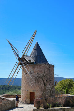 tourist visiting old windmill in goult village, high provence