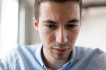 Close up of worried young businessman checking out bills, financial problem.