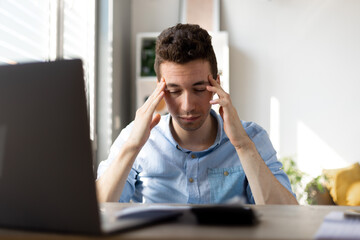 Businessman office working holding sore head pain from desk working and sitting all day using laptop computer or notebook suffering headache sick worker overworking concept.