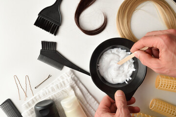 Stylist preparing hair care and coloring product on white table