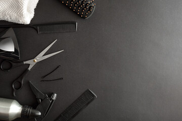 Hairdressing background with various tools on black background