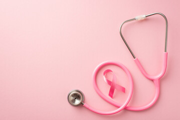 Breast cancer awareness concept. Top view photo of pink satin ribbon and stethoscope on isolated pastel pink background with copyspace