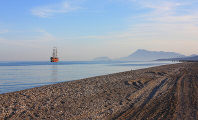 Red sailing ship in the sea in sunset time	
