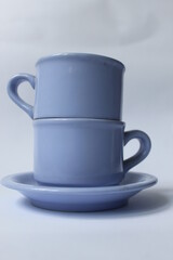 photo of a pile of purplish blue coffee cups Placed on a white background