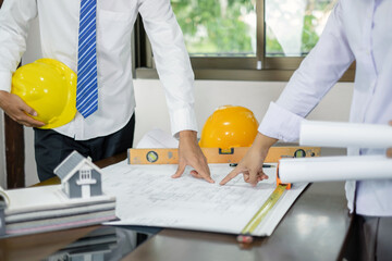 Team of male and female engineers and architects, working meeting, discussing construction, and...