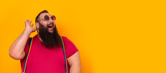 Big funny bearded gay man wearing sunglasses and a happy surprise expression 
