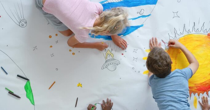Drawing, picture and creativity by a group of children at school, kindergarten or preschool in a class. Top view of young kids, learners and students doing art work in a classroom from above