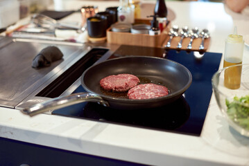 Cooking juicy tasty burger organic meat on hot pan in the kitchen at home. Cutlets fried in a frying pan. Food concept..