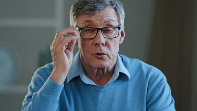 Close up shocked wrinkled male face old Caucasian businessman feeling amaze confused puzzled 60s pensioner take off eyeglasses looking at camera with interested expression listening unexpected news